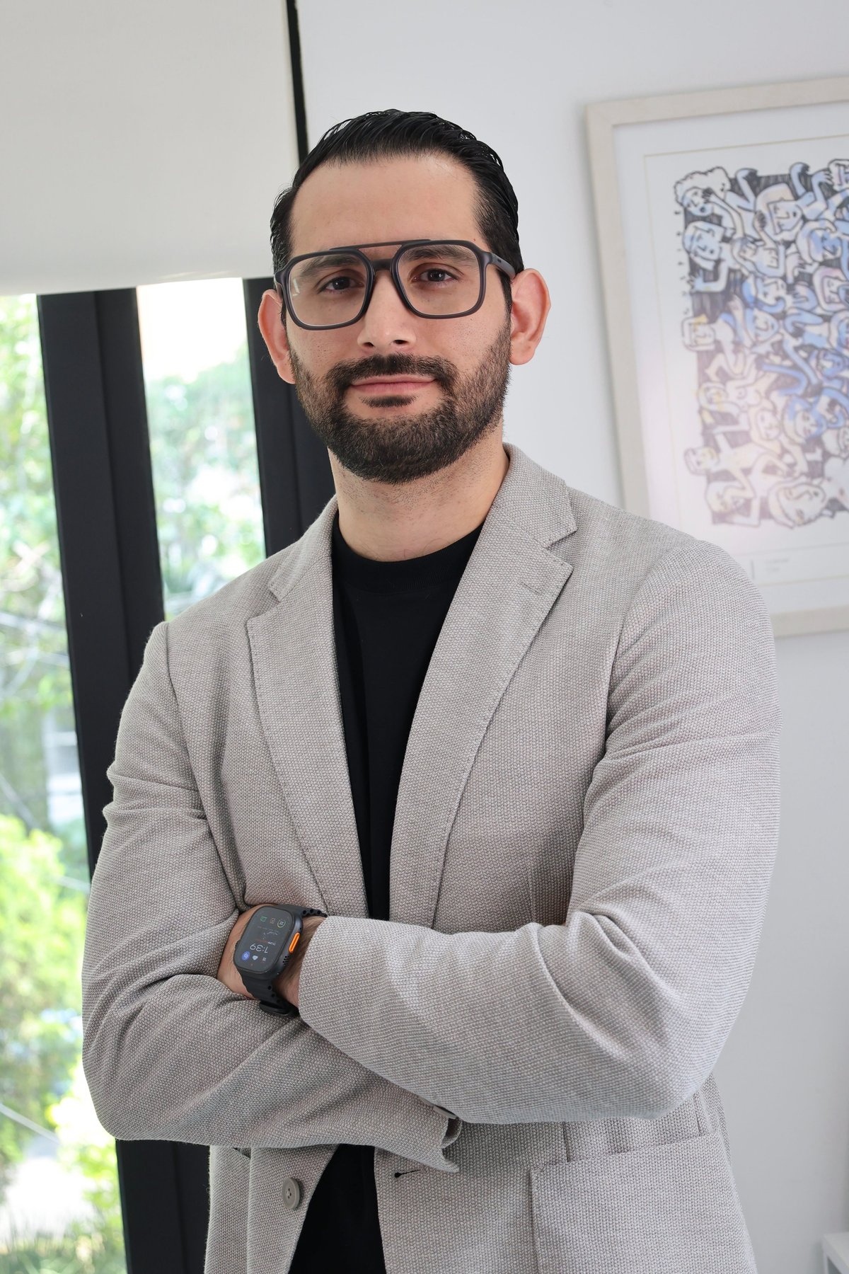 Retrato del Dr. Carlos Alberto Mojica López, cirujano ortopédico especialista en cadera y rodilla, con saco gris y brazos cruzados